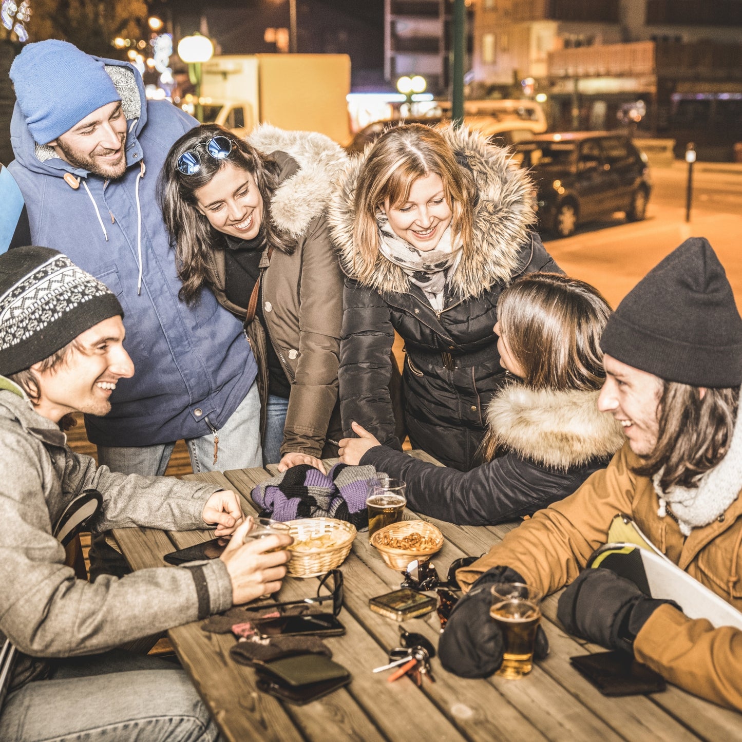 Friends staying warm while socializing outdoors on a cold winter night